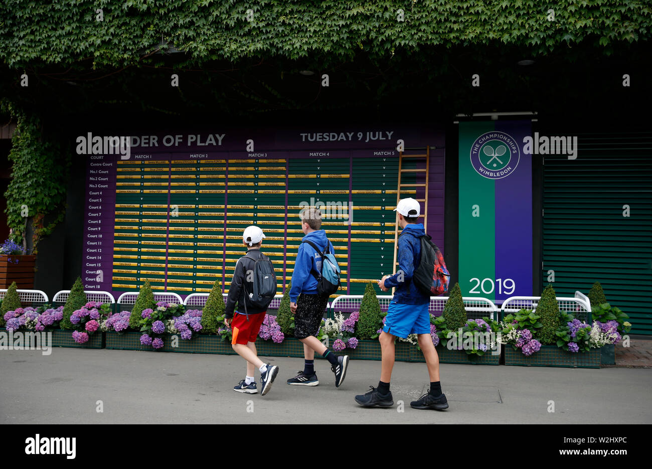 Londres, Grande-Bretagne. 09 juillet 2019. Les enfants passent par le conseil d'ordre de jeu au cours de la huitième journée de la Tennis de Wimbledon 2019 à Londres, en Grande-Bretagne, le 9 juillet 2019. Credit : Han Yan/Xinhua/Alamy Live News Banque D'Images