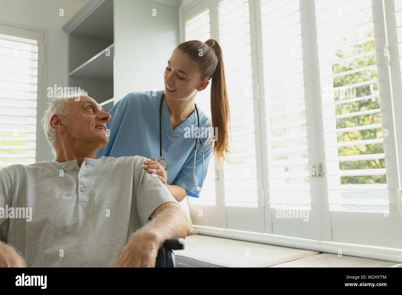 Femme avec active senior man in wheelchair at home Banque D'Images