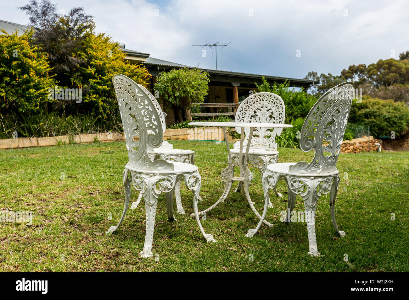 Fonte blanche table et chaises sur la pelouse en plein air Banque D'Images