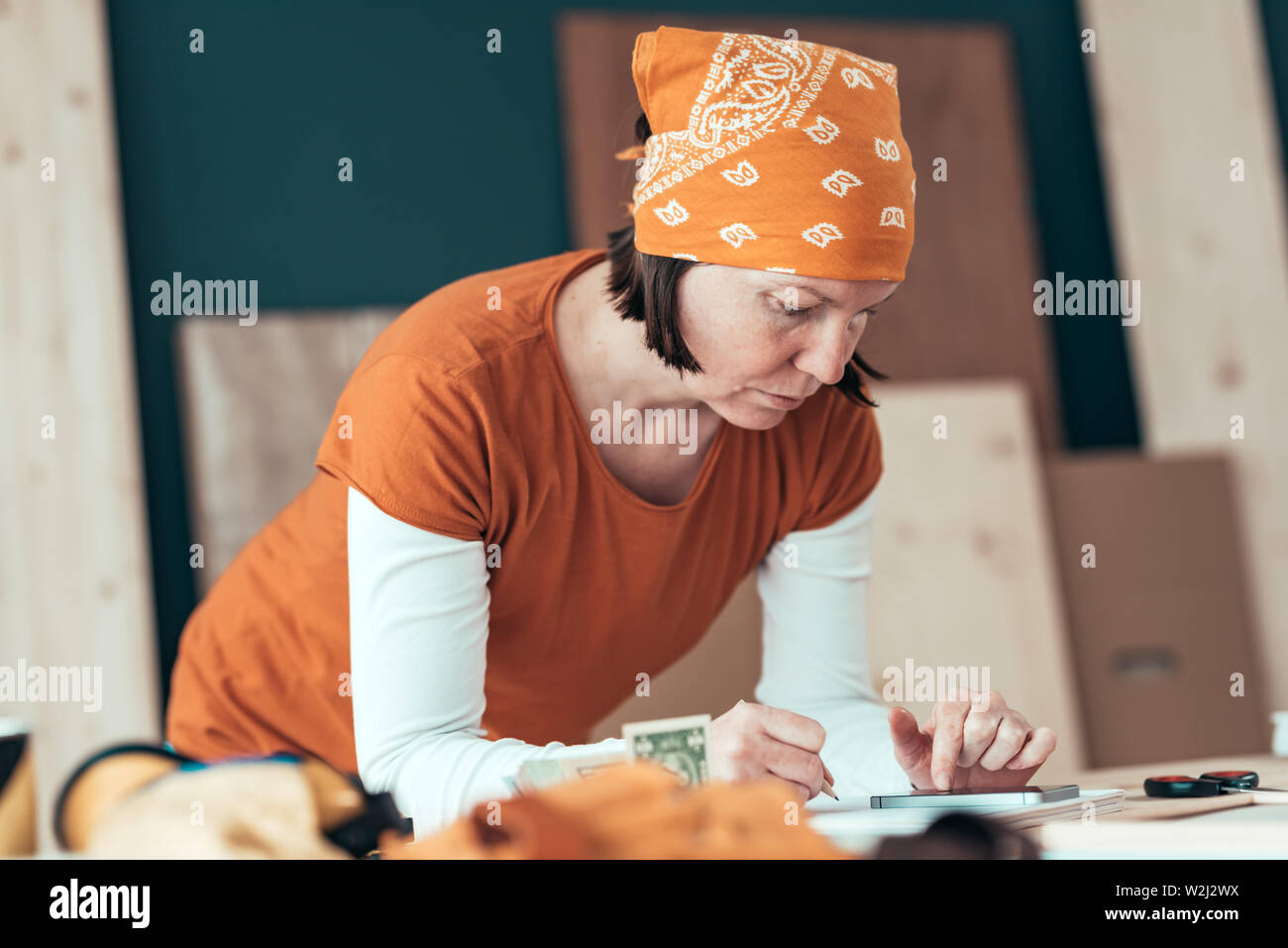 Female carpenter avec mouchoir de tête avec des problèmes financiers en menuiserie ébénisterie atelier, selective focus Banque D'Images