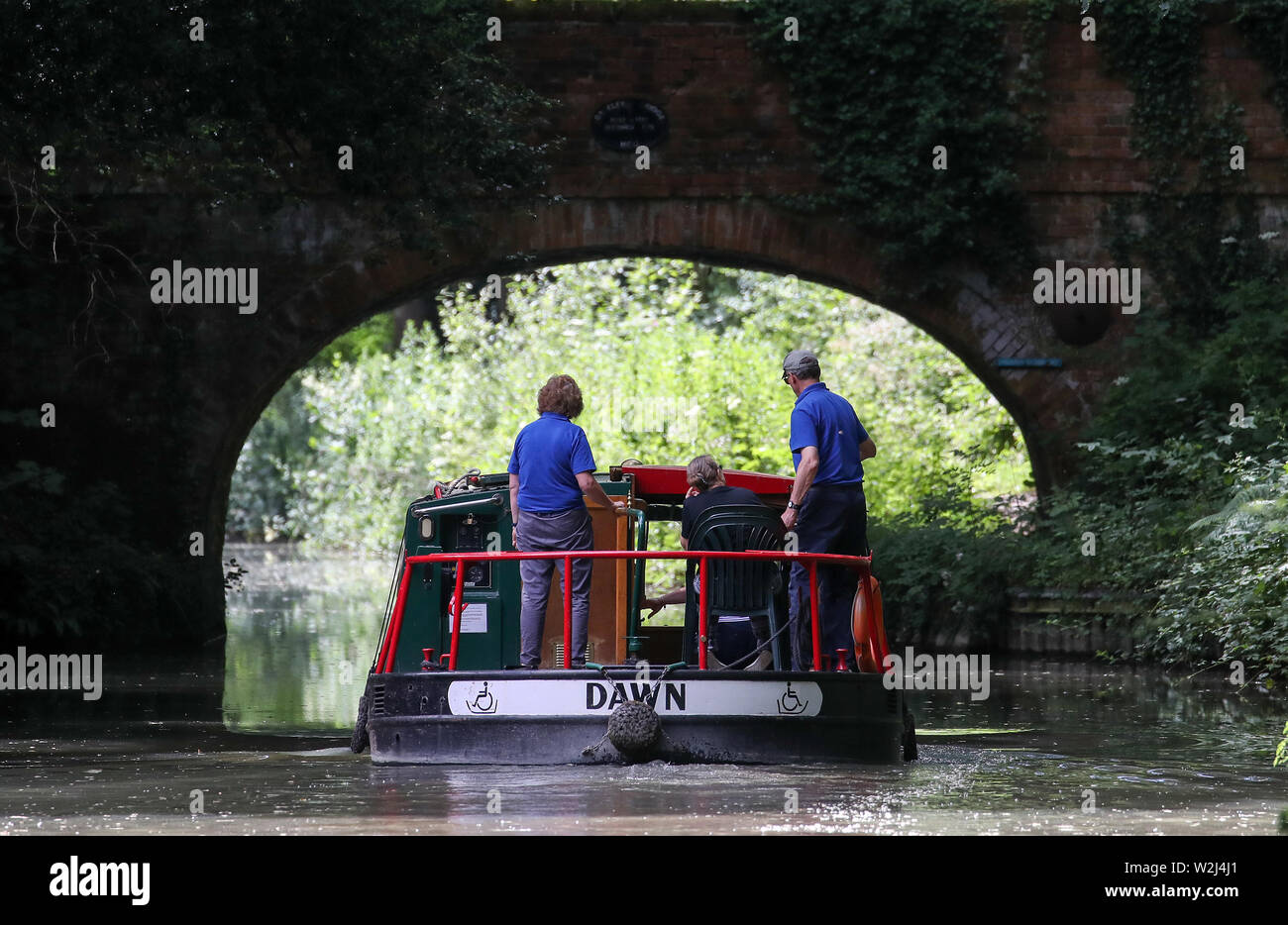 Un bateau est conduite le long du canal près de Basingstoke à Dogmersfield dans le Hampshire. Banque D'Images