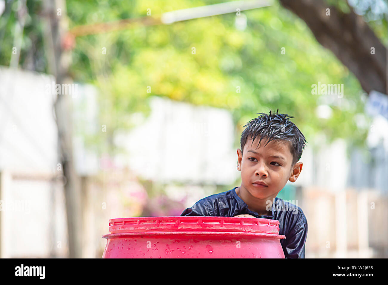 Asian boy jouer dans l'eau de Songkran festival ou nouvel an Thaï en Thaïlande. Banque D'Images