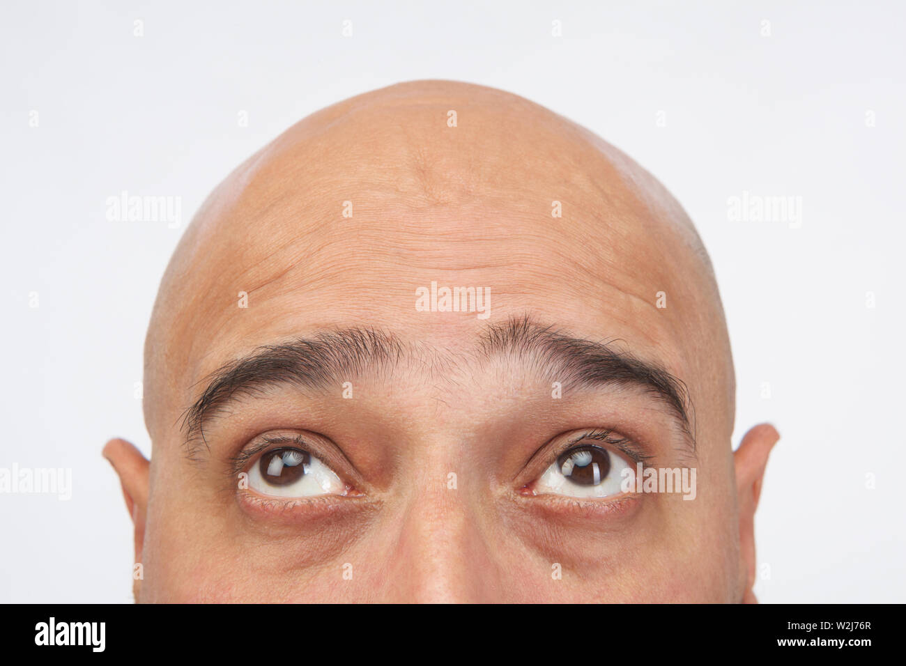 Close up of an Indian homme chauve looking up Banque D'Images