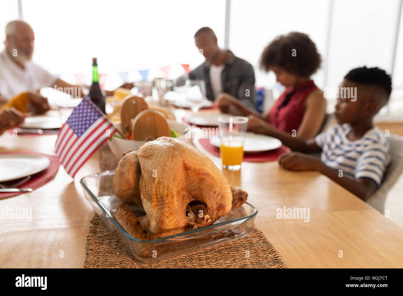 Multi-generation family prier avant d'avoir repas sur table à manger Banque D'Images