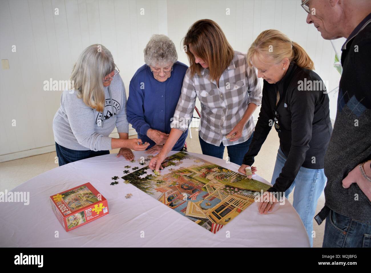 Les femmes de vraie famille à rassembler doing crossword puzzle - Mère à 90 et 2 filles et dans les lois au barbecue s'amuser ensemble Banque D'Images