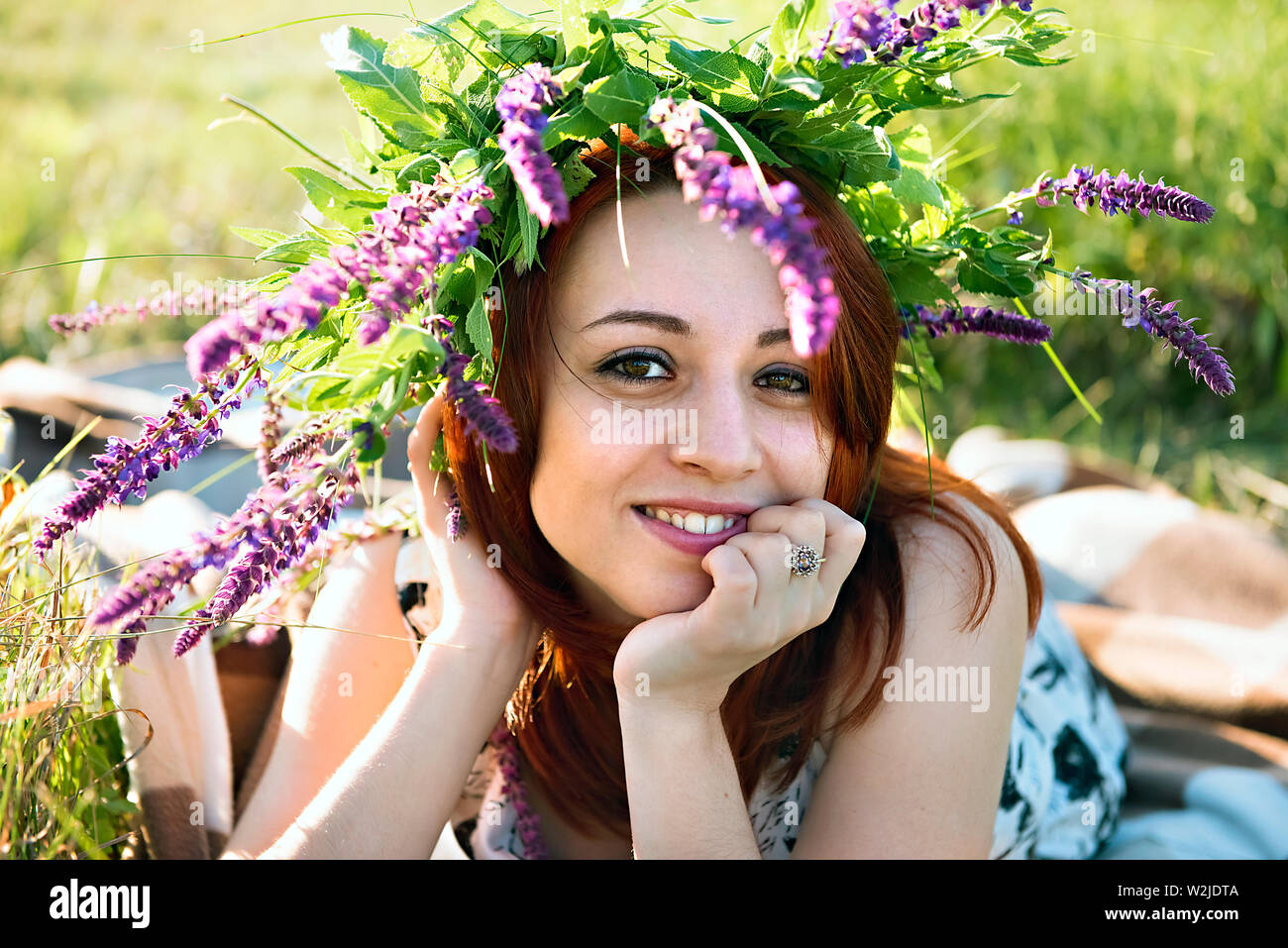 Fille avec une couronne sur sa tête couché sur l'herbe Banque D'Images