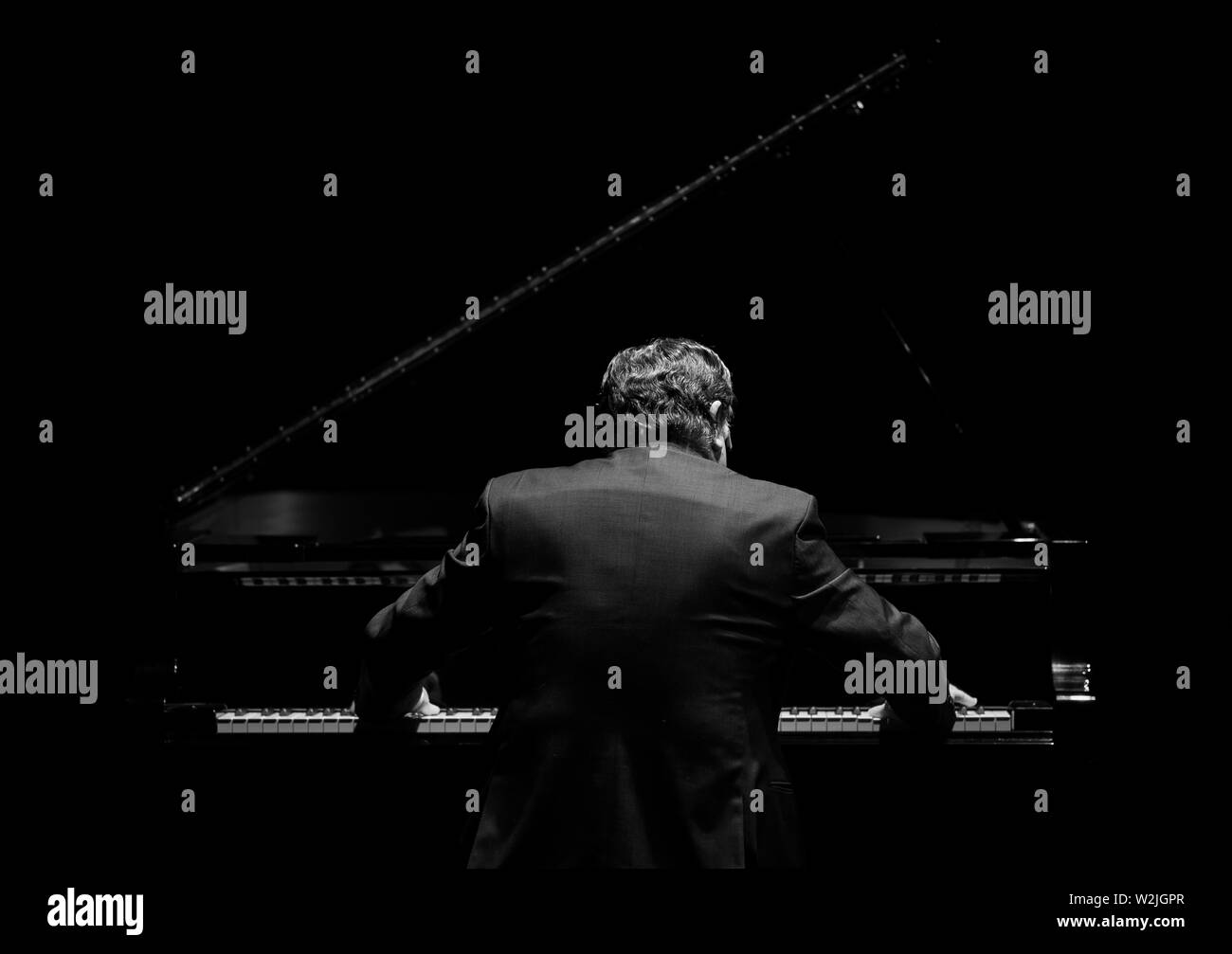 Le Pianiste jouant dans l'obscurité de l'arrière Banque D'Images