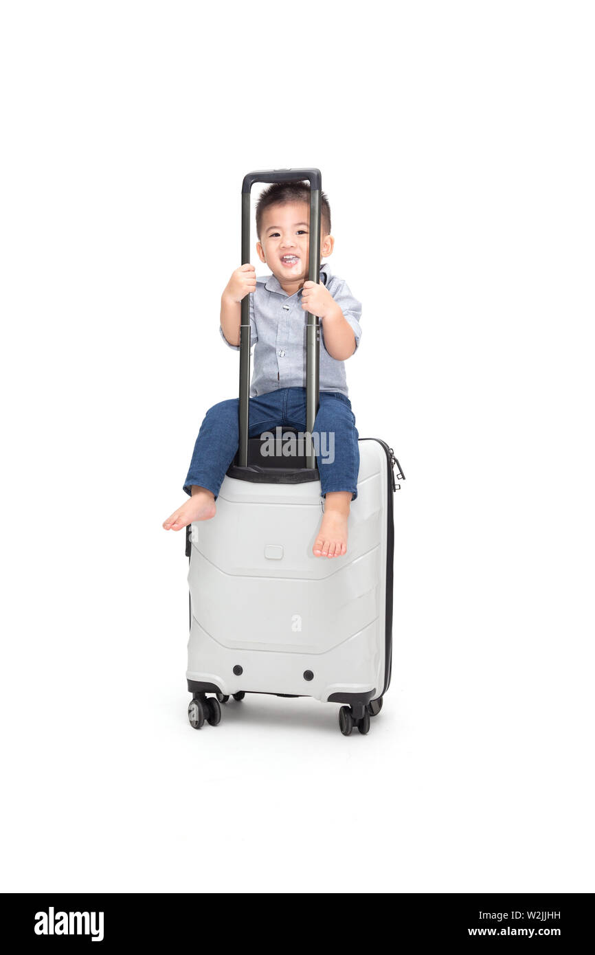 Happy Asian baby boy sitting sac de voyage ou une valise isolé sur fond blanc, les voyages et de nouvelles aventures voyage en famille pour enfants concept Banque D'Images