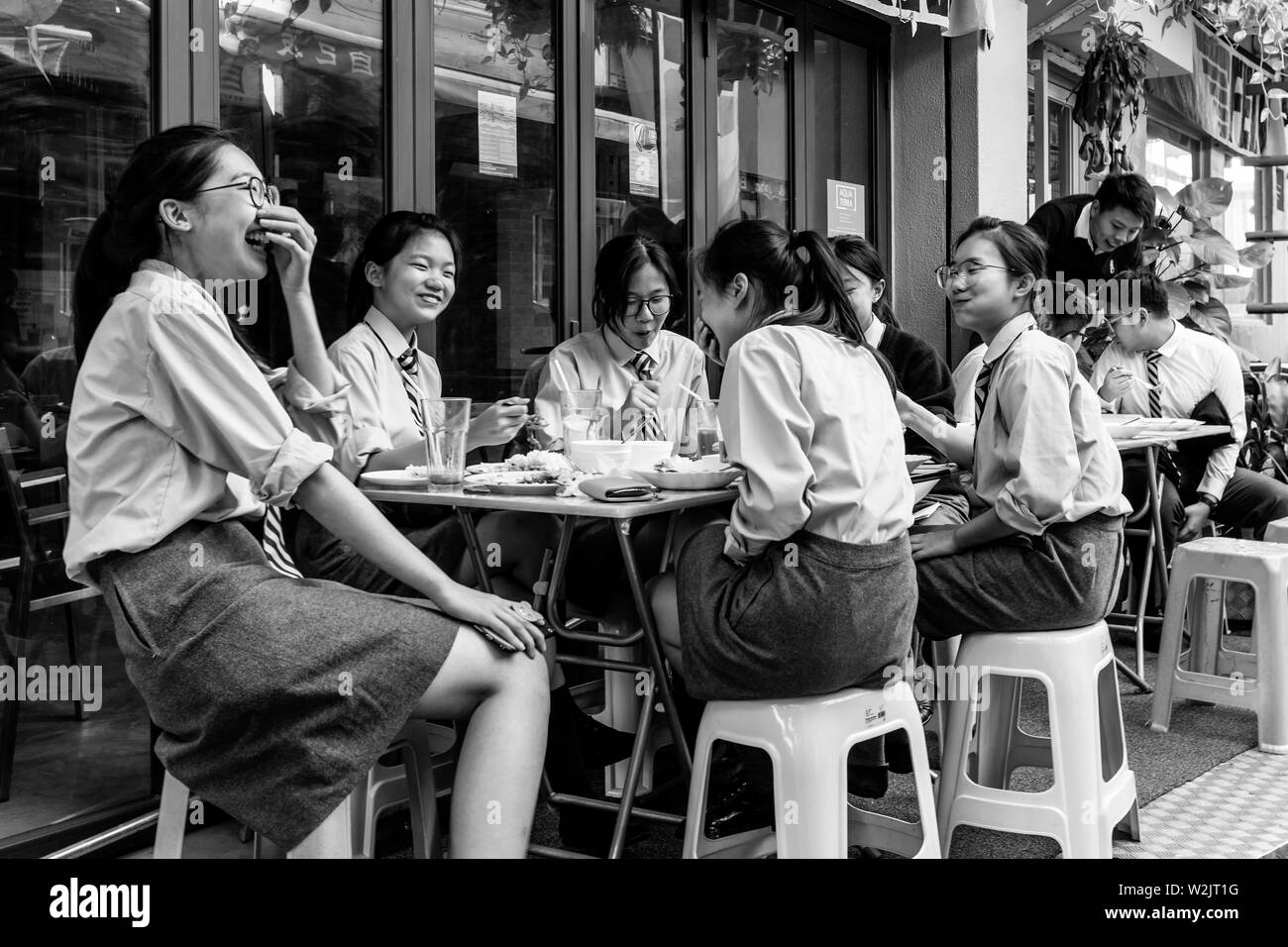 Les élèves de l'école des femmes de manger le déjeuner dans un café, Stanley, Hong Kong, Chine Banque D'Images