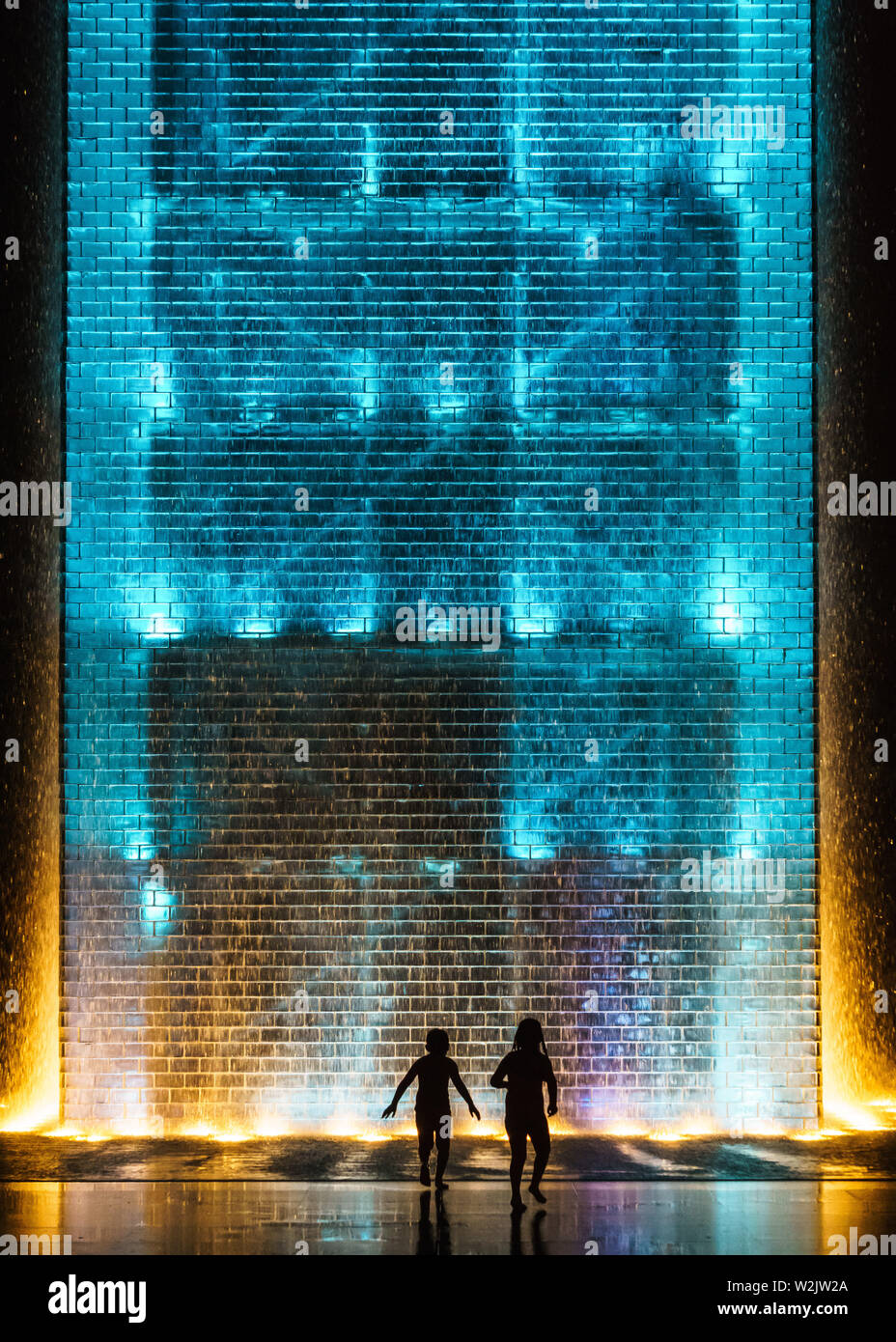 Silhouettes de deux enfants qui jouent près de la fontaine de la Couronne, Chicago Banque D'Images