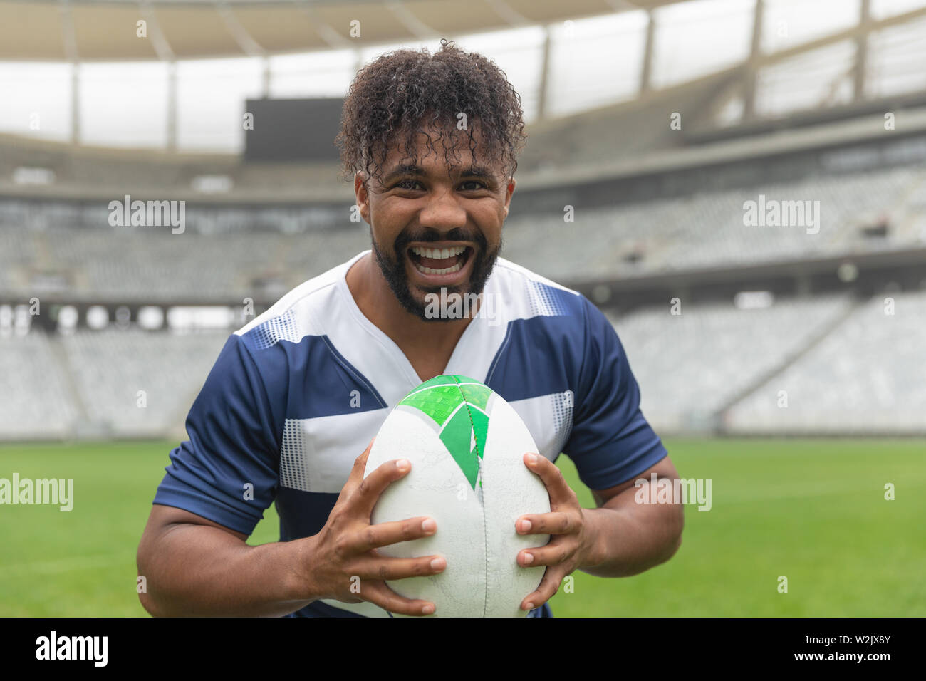 Happy African American Rugby player debout avec ballon de rugby au stadium Banque D'Images