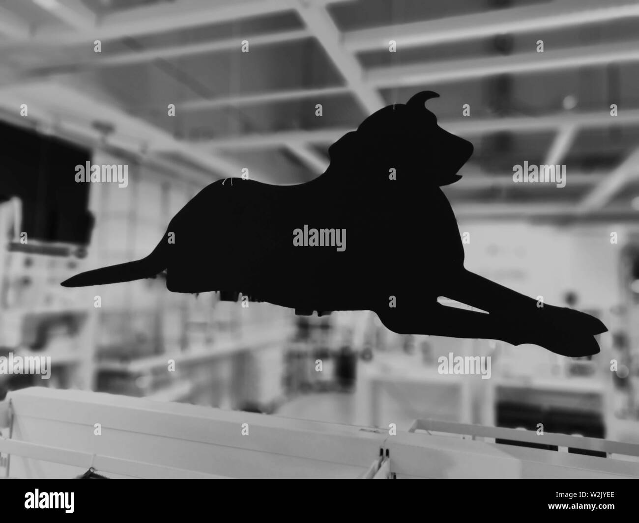 Carton noir et blanc silhouette chien avec arrière-plan flou Banque D'Images