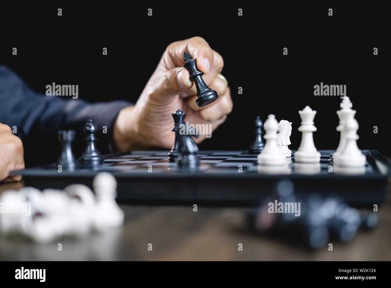 Businessman jouant aux échecs et de penser à propos de la stratégie de renverser l'équipe opposée l'écrasement et l'analyse du développement pour gagner et pour réussir. Banque D'Images