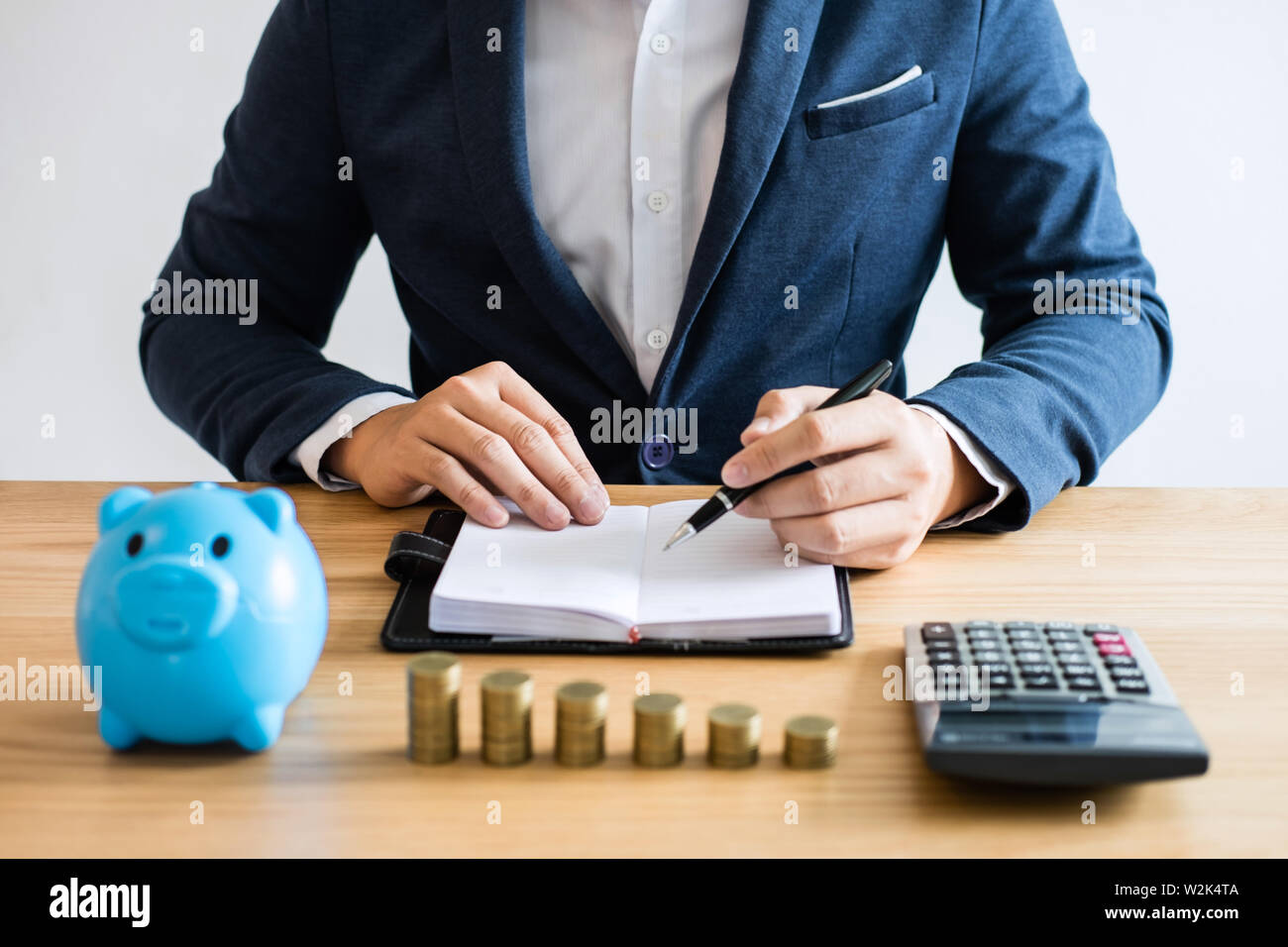 Piles de monnaie pour renforcer les entreprises en pleine croissance au profit et a l enregistrement avec tirelire homme d affaires l utilisation de documents et calculatrice economiser de l argent po...