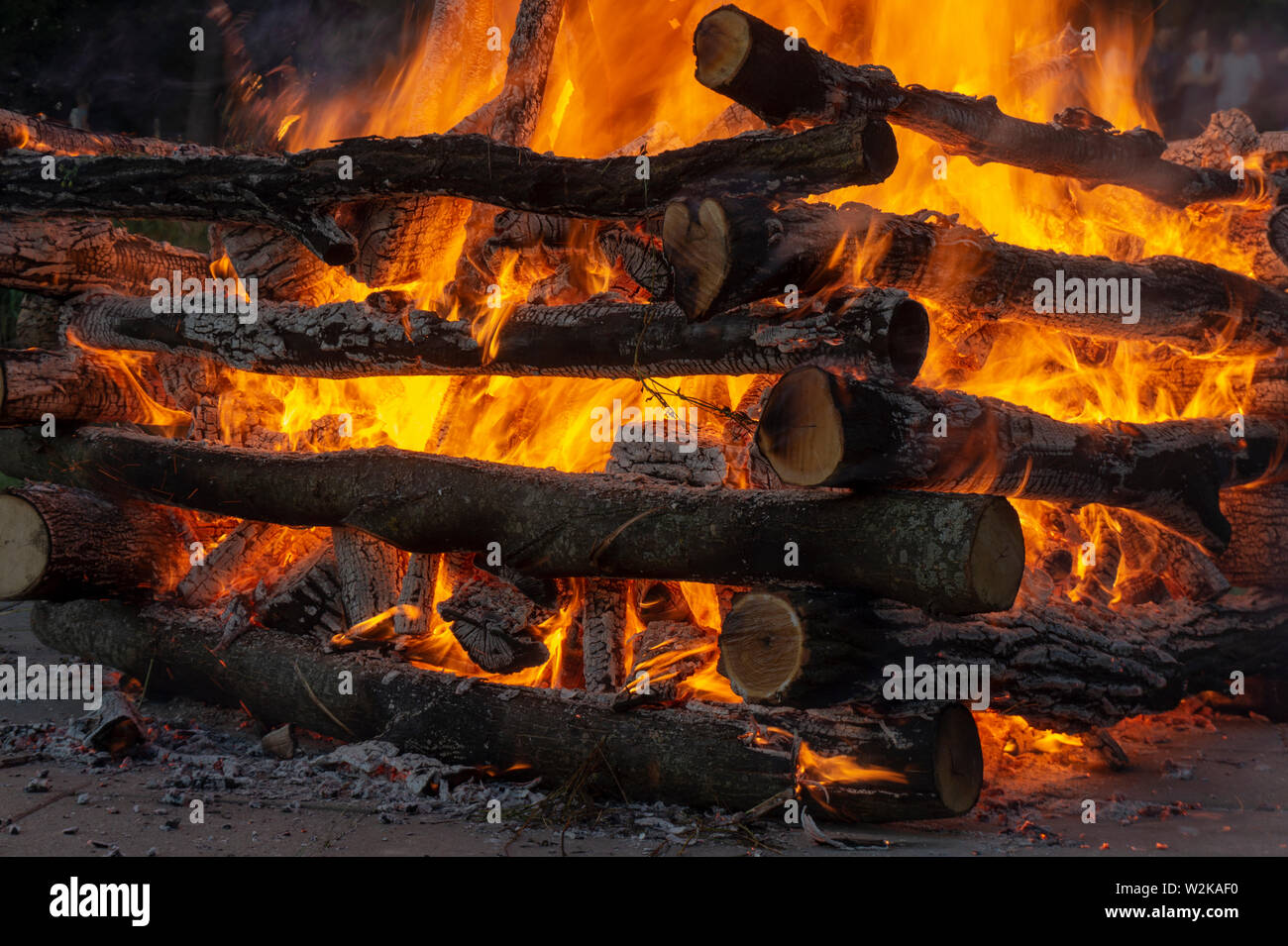 Feu Ardent avec billes de bois empilés contenant un feu avec des flammes orange chaud dans une vue en gros plan Banque D'Images