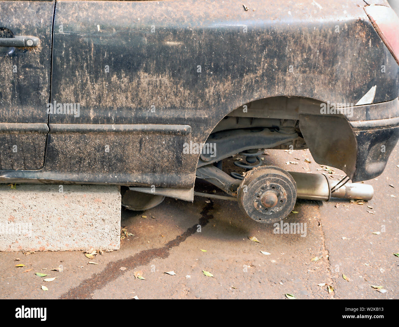 Un accident de voiture construit sur des pierres de l'ancien bleu foncé ou noir, les roues sont démontées, la peinture sale, rayé corps plein de dégâts. Banque D'Images