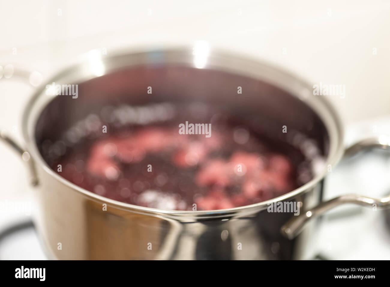 Résumé fond flou de bleuets l'ébullition dans une casserole. La cuisson de la confiture de bleuets. Banque D'Images