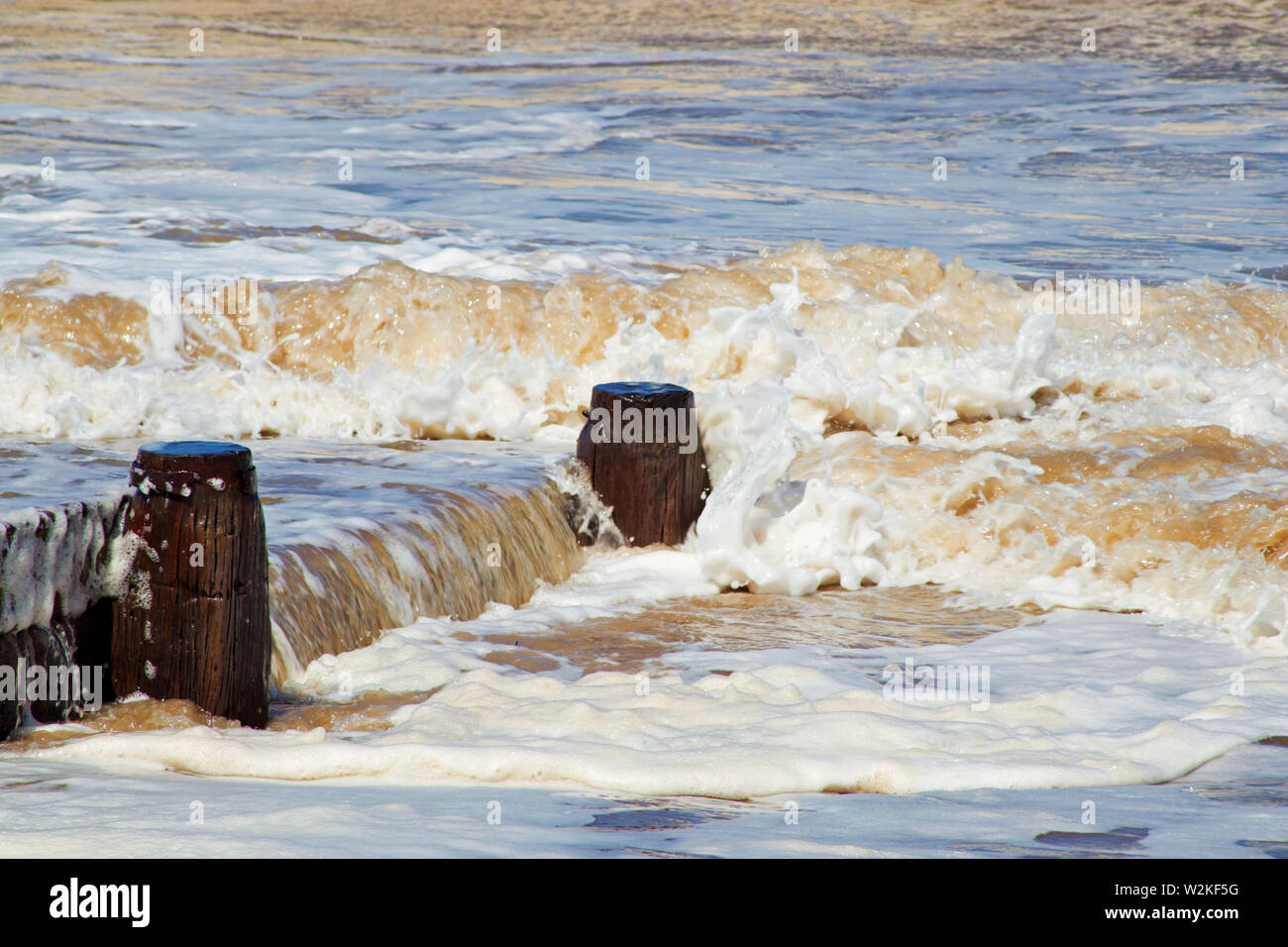 Les vagues de mousse faire un motif agréable contre les défenses de la mer à Fleetwood, Lancashire Banque D'Images