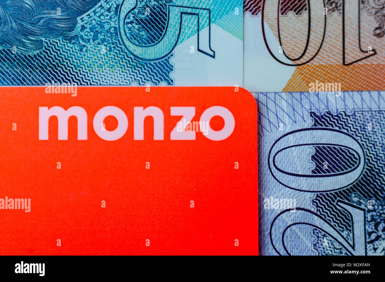 Monzo carte bancaire sur l'arrière-plan de la livre sterling l'argent des dénominations différentes. Banque D'Images