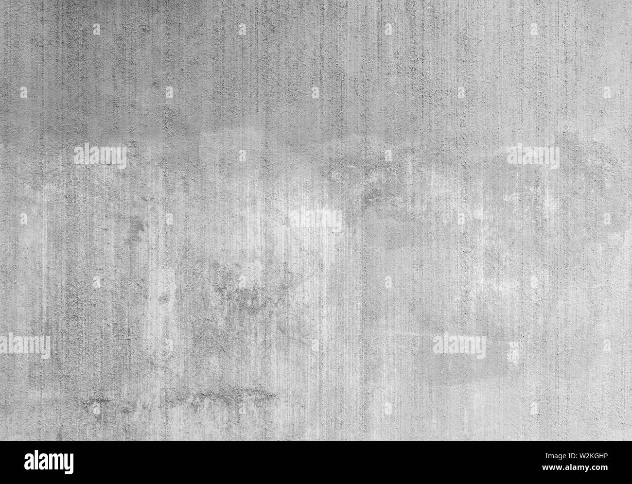 Plâtré, peint, patiné, rugueux et gris béton ou mur de pierre avec des notes à la suite de l'enlèvement des graffitis en noir et blanc. Copier l'espace. Banque D'Images