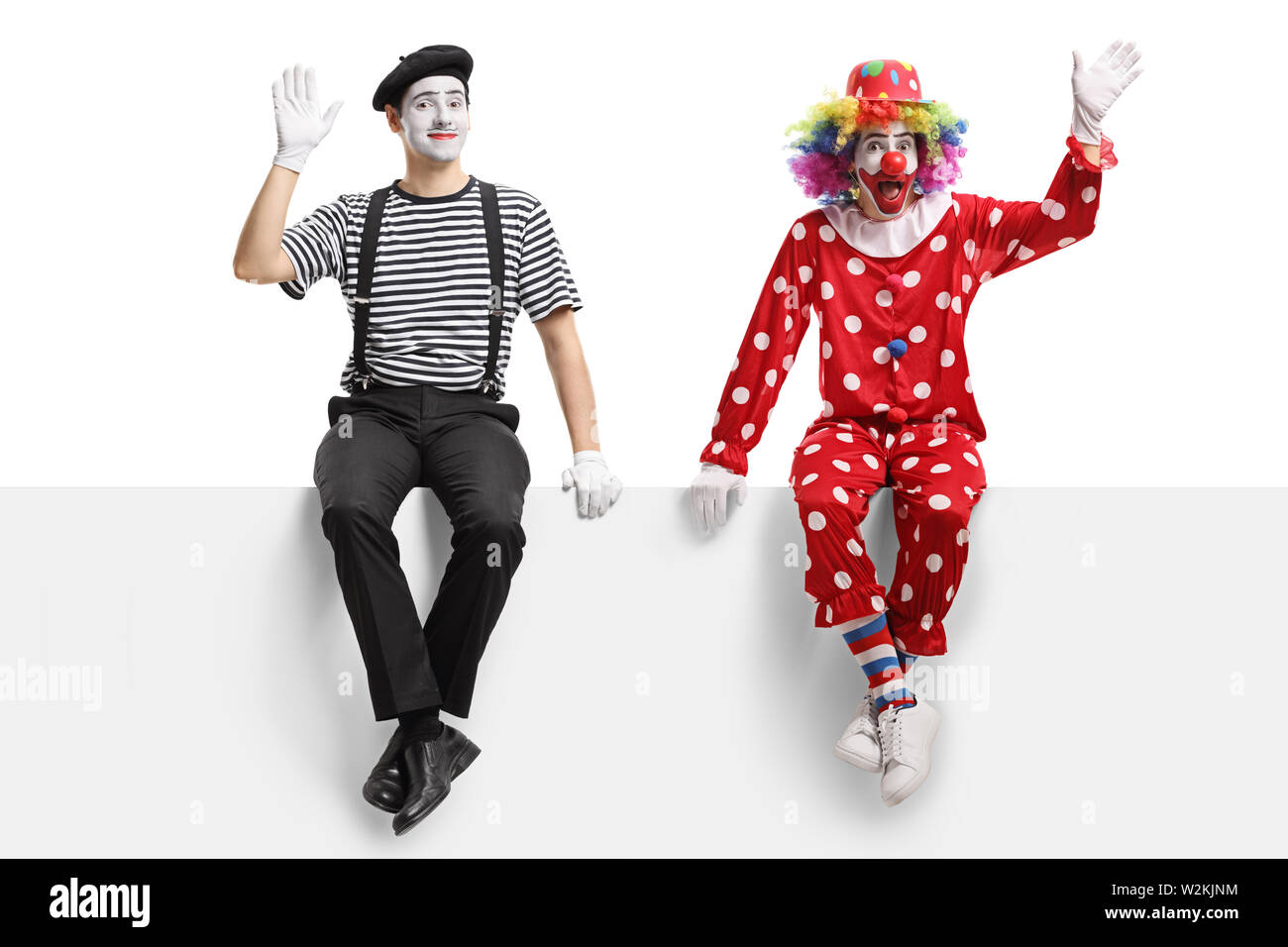 Longueur totale d'un clown et d'un mime assis sur un bord et forme isolé sur fond blanc Banque D'Images