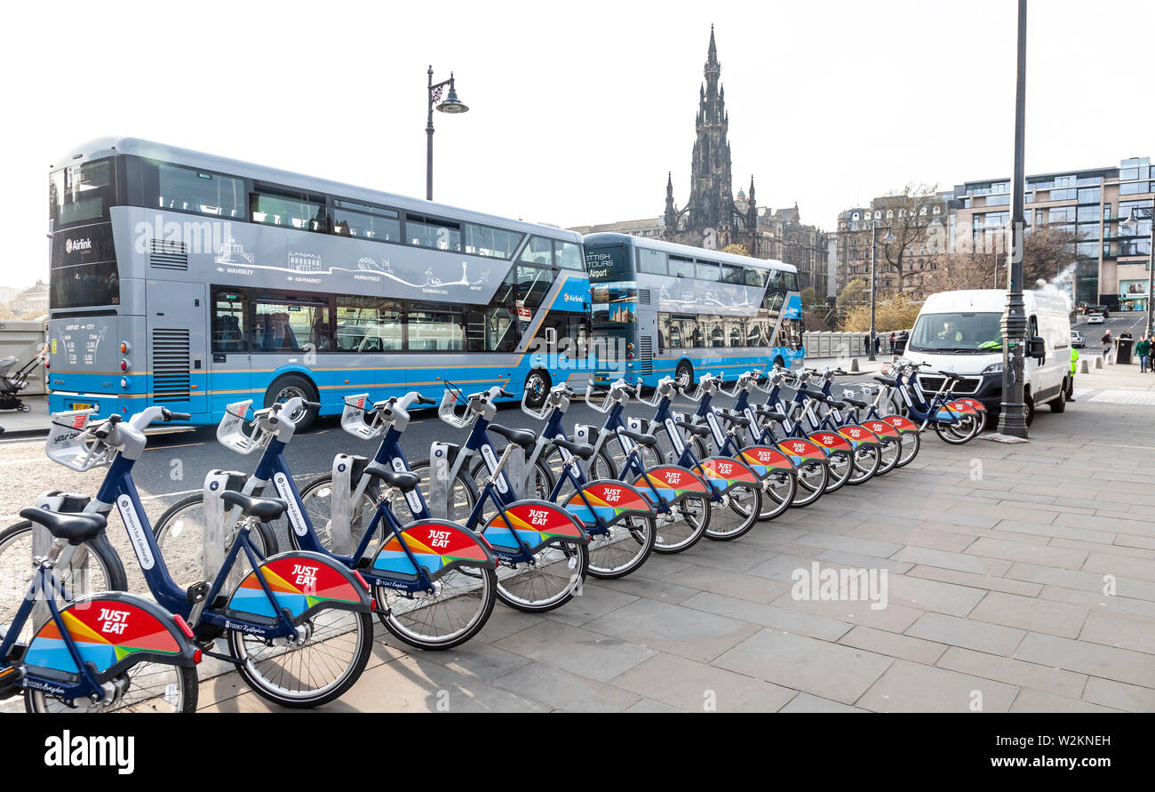 Transport pour Edimbourg (manger) les vélos et deux double decker bus aéroport airlink sur Waverley Bridge dans le centre d'Édimbourg, Écosse, Royaume-Uni Banque D'Images