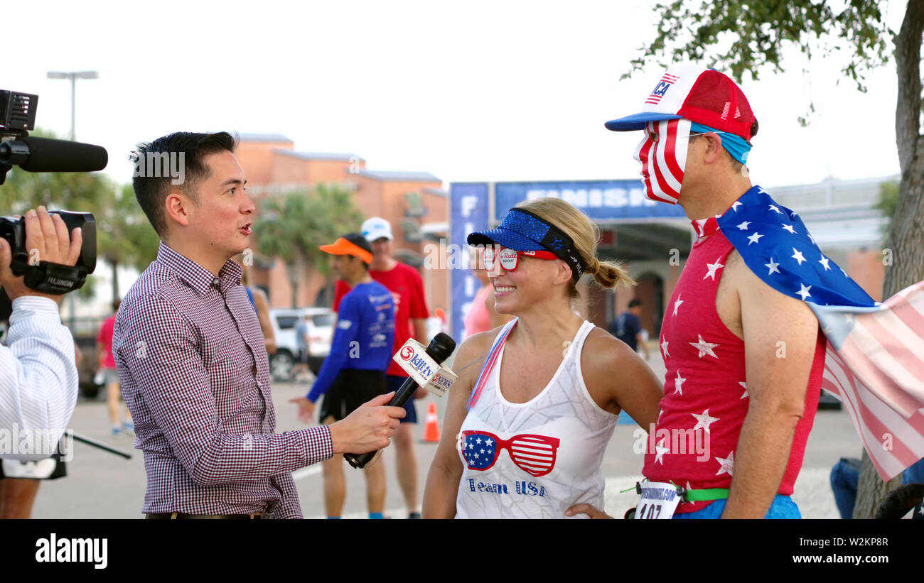 Journaliste Steven Cavazos de KIII 3 TV News de Corpus Christi, Texas USA interviews participants costumés en quatre pour la quatrième / 4 Mile Fun Run. Banque D'Images