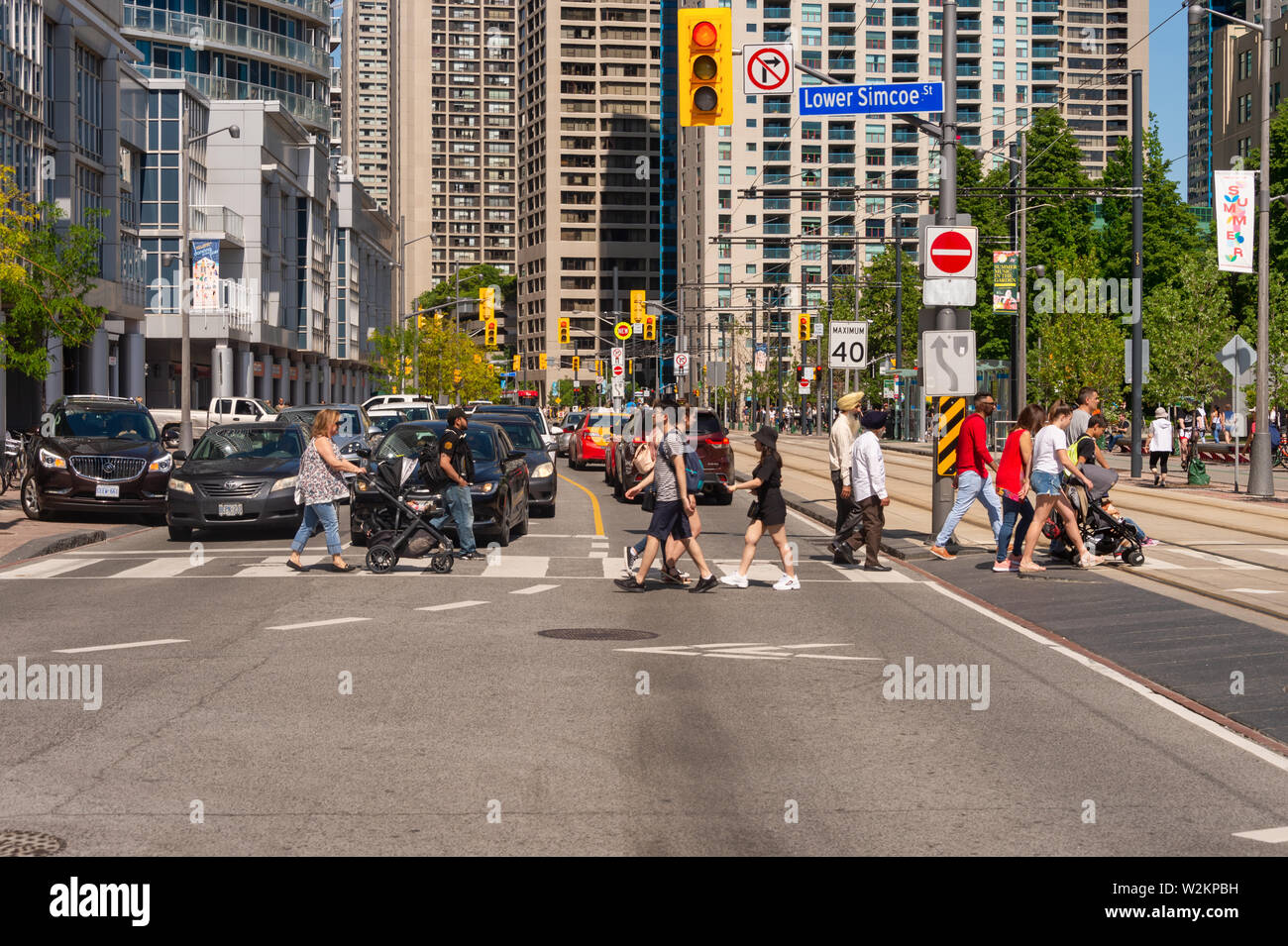 Toronto, Canada - 22 juin 2019 : une foule de personnes traversant Queens Quay W street dans le centre-ville de Toronto Banque D'Images