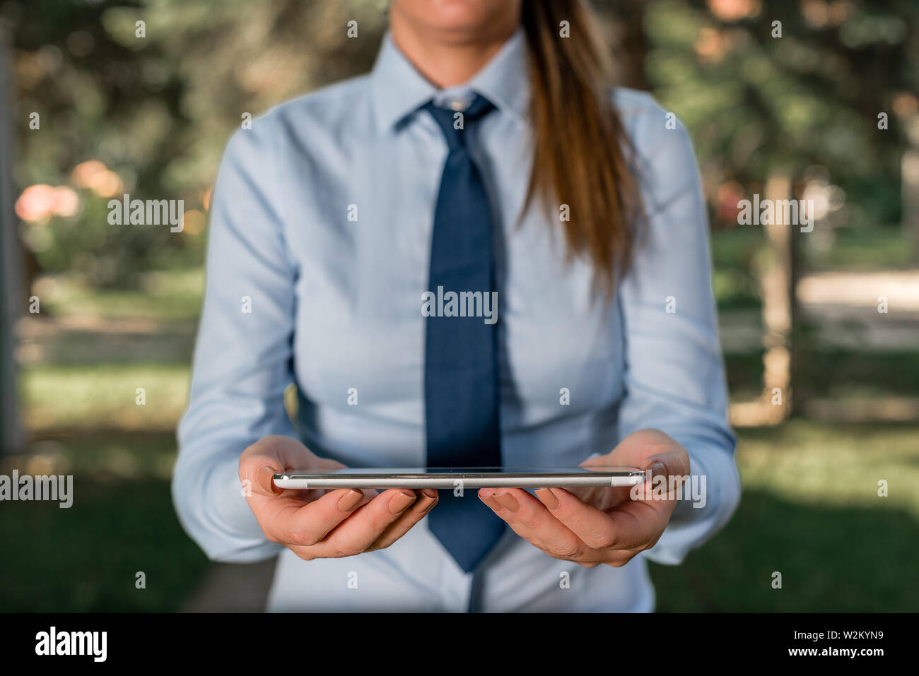 Femme d'affaires en chemise avec une cravate holding lap top téléphone  mobile dans la main Photo Stock - Alamy