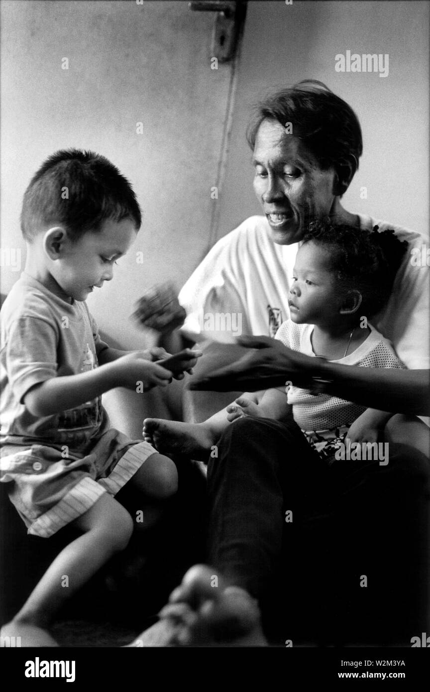 Jouer avec ses amis les enfants adoptés, Salina, 43, est une transsexuelle Malais et a été diagnostiquée séropositive en 1994. Une partie de la Vie Positive international project (www.positivelives.org) les documents que l'impact de l'épidémie mondiale de VIH/SIDA. Kuala Lumpur, Malaisie, 2001..'vit, la Malaisie 2001 positif' Banque D'Images