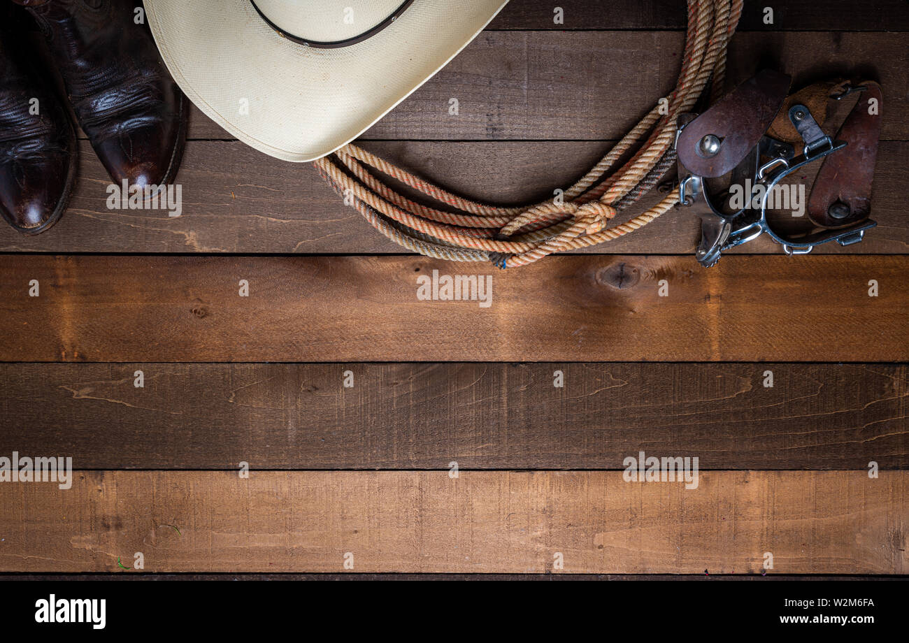 American Cowboy Articles incluing un lasso dards et un chapeau de paille traditionnel sur une planche en bois historique Banque D'Images