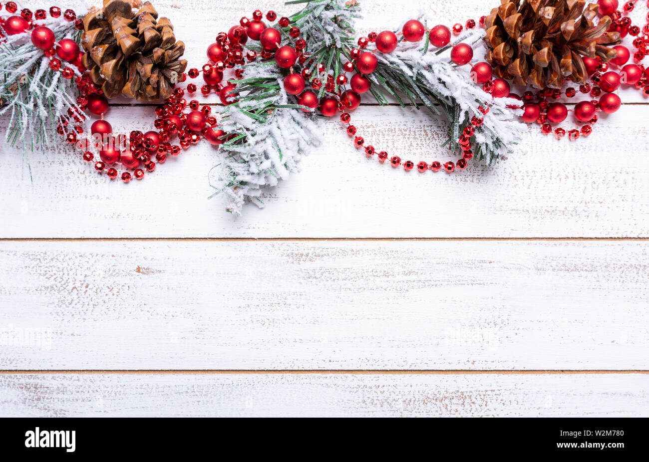 Décorations de Noël sur un fond de bois blanc avec copie espace. Cônes de pin, Garland, baies et des branches de pins Banque D'Images