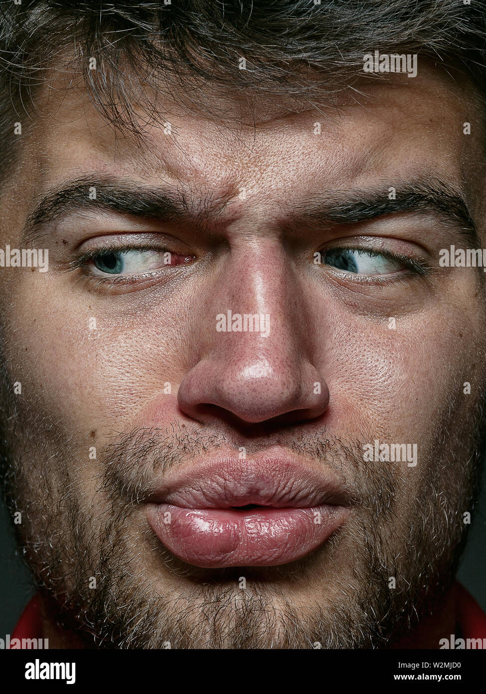 Close up portrait of young man et émotionnel. Détail de sem - allemand très modèle masculin avec la peau bien entretenu et lumineux de l'expression du visage. Concept d'émotions humaines. Sensation dégoûtante. Banque D'Images
