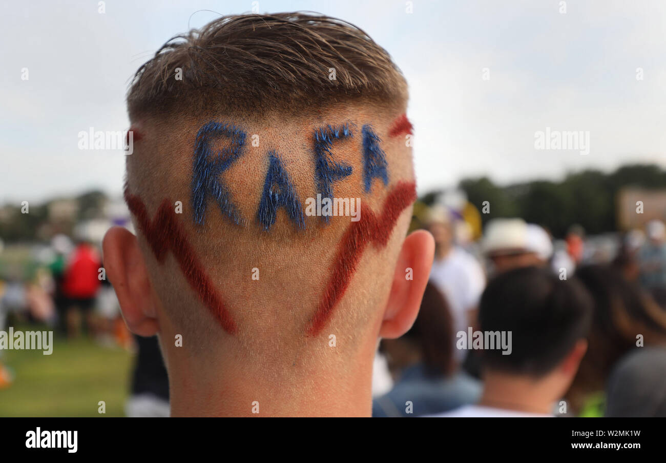 14 ans Seth Briggs-Williams, qui a Rafa coupé en l'arrière de ses cheveux, la queue dans le parc de Wimbledon au jour 9 des championnats de Wimbledon à l'All England Lawn Tennis et croquet Club, Londres. Banque D'Images