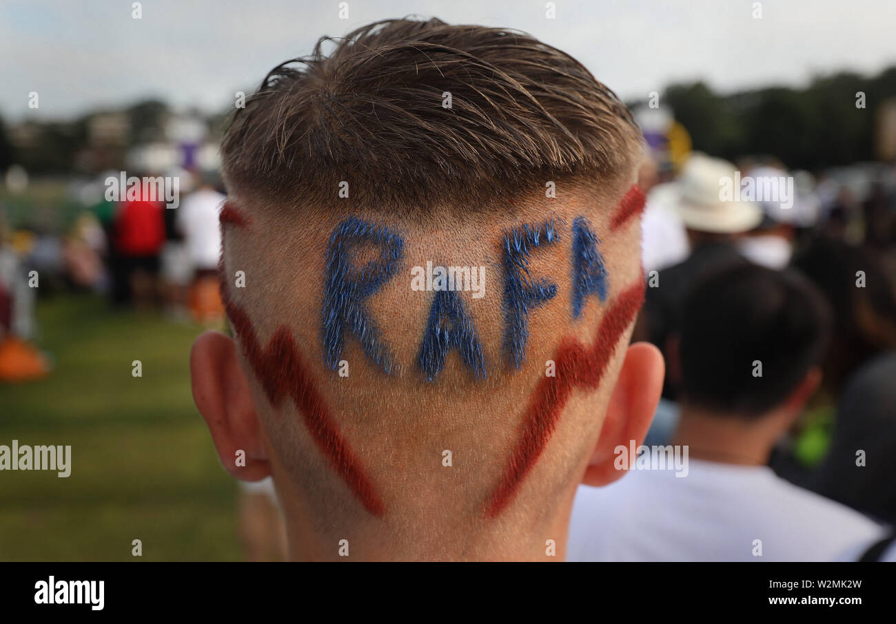 14 ans Seth Briggs-Williams, qui a Rafa coupé en l'arrière de ses cheveux, la queue dans le parc de Wimbledon au jour 9 des championnats de Wimbledon à l'All England Lawn Tennis et croquet Club, Londres. Banque D'Images