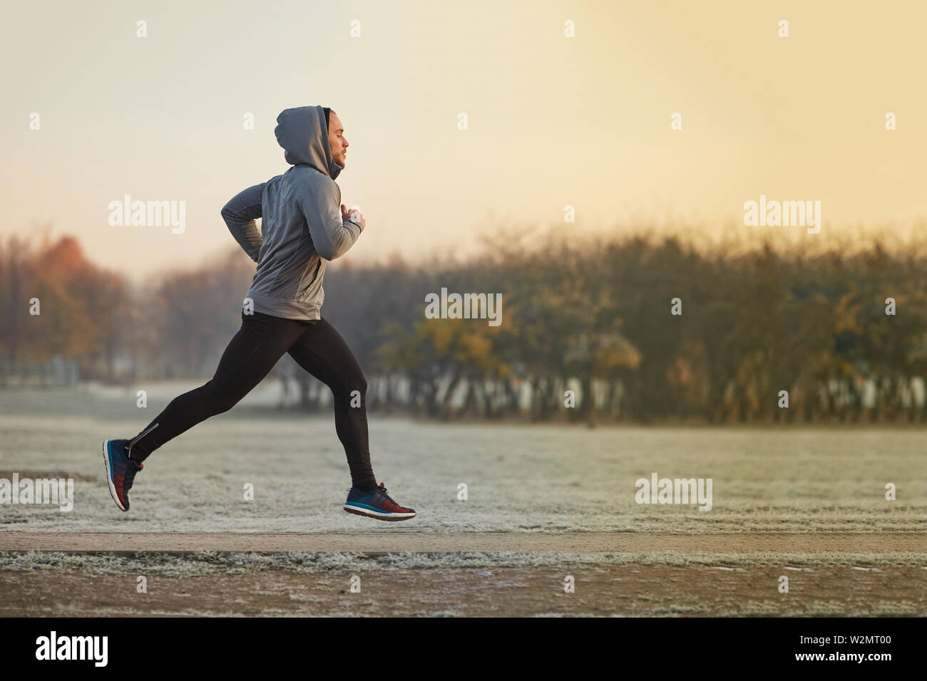 Jeune homme athlétique tournant au parc en automne froid matin Banque D'Images