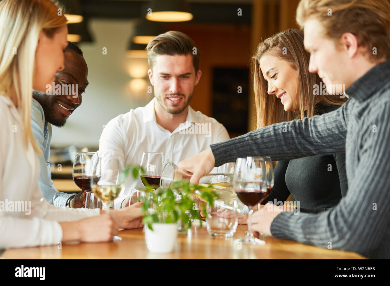 Les jeunes ayant un verre de vin ensemble dans un bistro ou restaurant Banque D'Images
