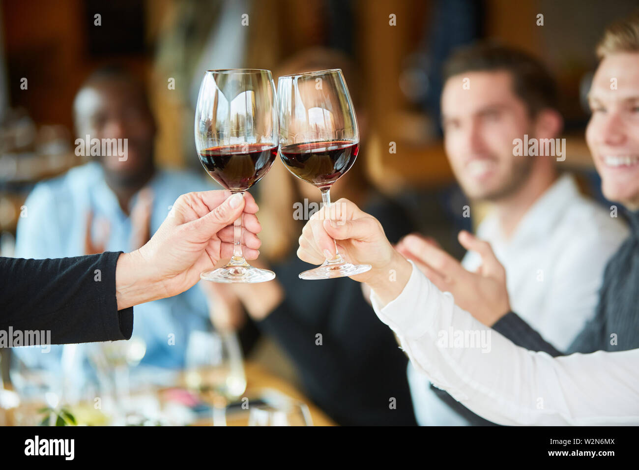 Les amis de célébrer une fête ensemble dans le restaurant et des toasts avec du vin rouge Banque D'Images