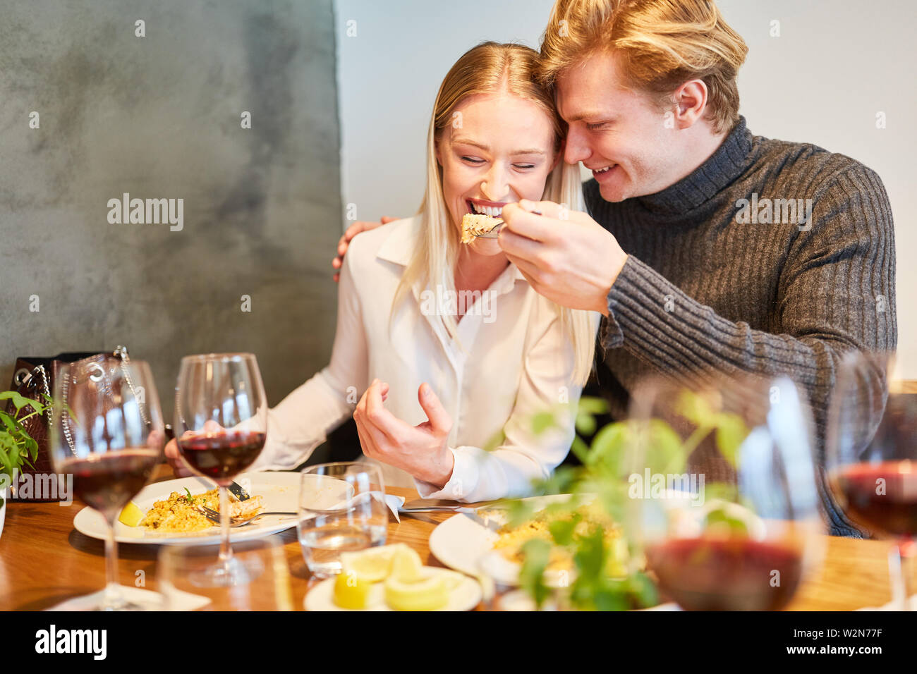 Jeune homme est l'alimentation de sa petite amie ensemble à déjeuner dans le restaurant Banque D'Images