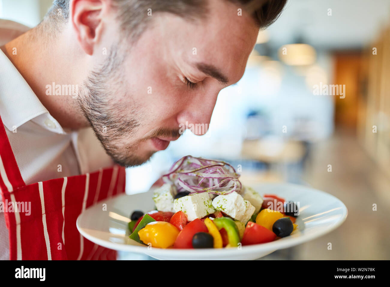 Waiter serving frais et savoureux dans le restaurant salade grecque Banque D'Images