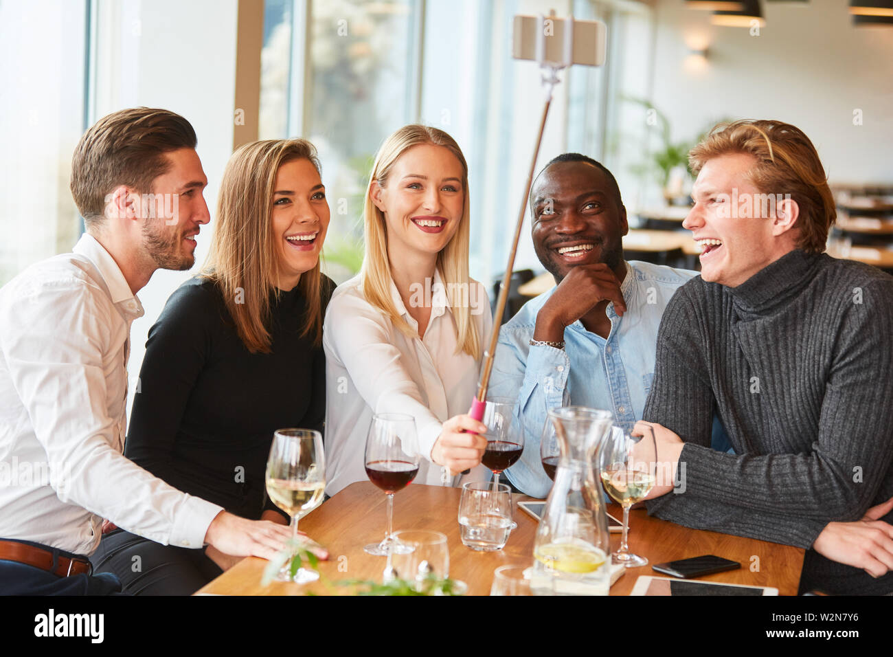 Groupe multiculturel de jeunes est de faire en selfies restaurant avec stick selfies Banque D'Images
