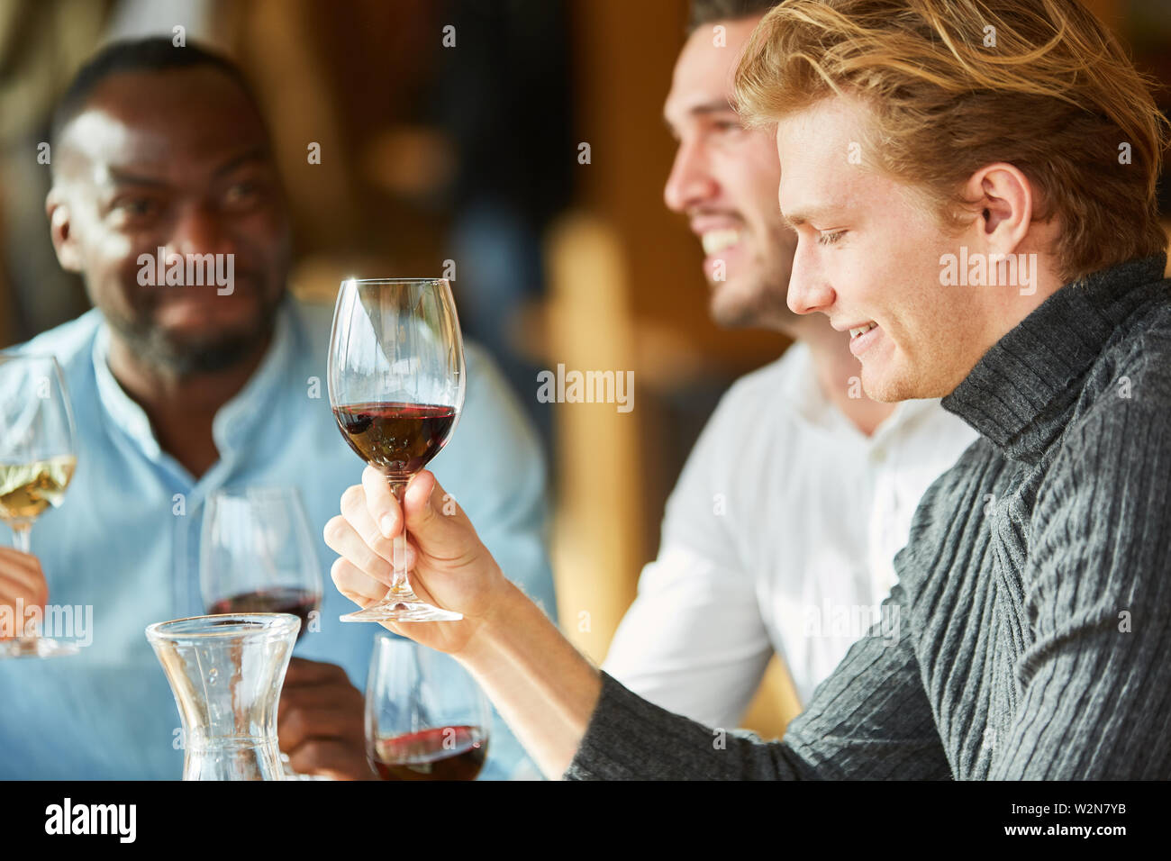 Les jeunes gens célébrer ensemble et boire du vin au restaurant ou bar Banque D'Images