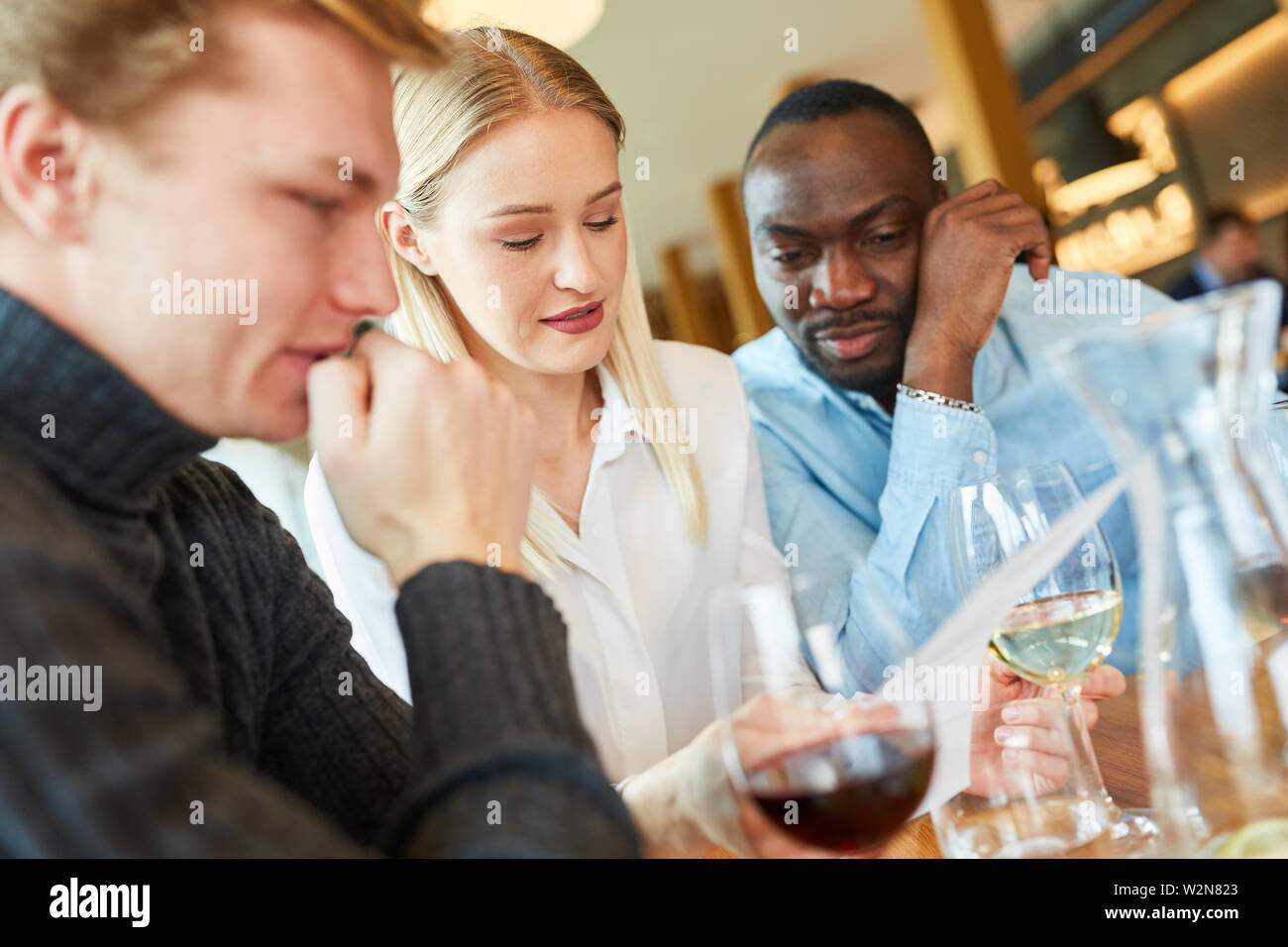 Les jeunes dans le restaurant tout en ordonnant de lire attentivement le menu Banque D'Images