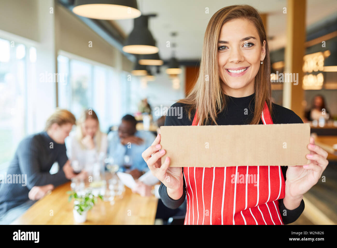 Serveuse dans le restaurant est titulaire d'un signe vide dans ses mains Banque D'Images
