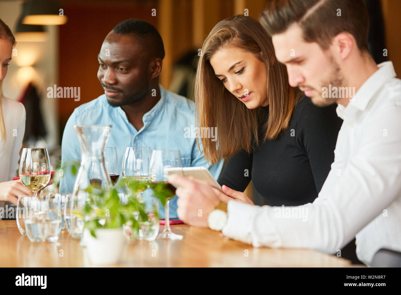 Les jeunes dans le restaurant sont constamment à la recherche de leur téléphone intelligent ou mobile Banque D'Images