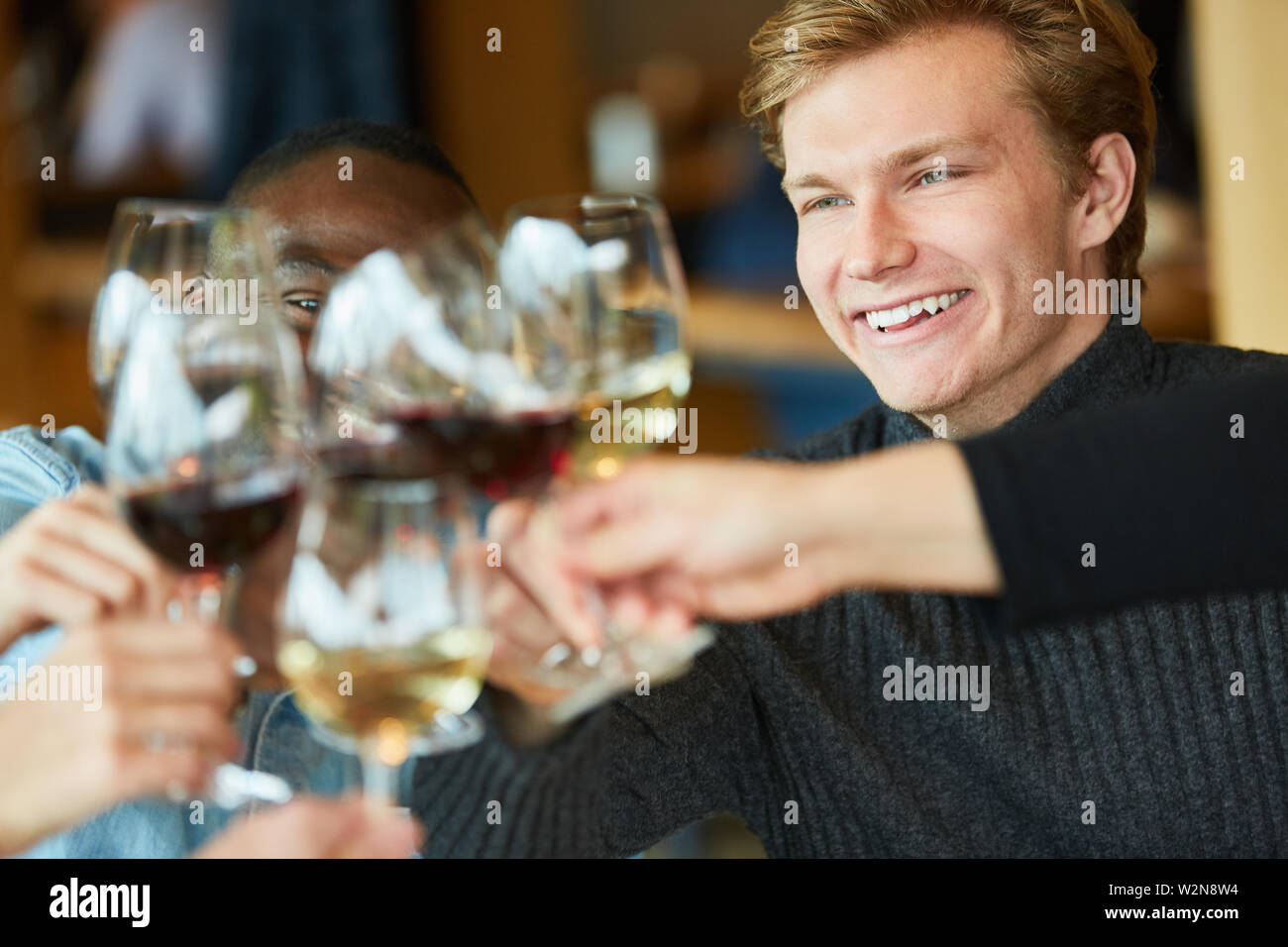 Jeune homme célèbre une fête avec des amis et le grillage avec un verre de vin Banque D'Images