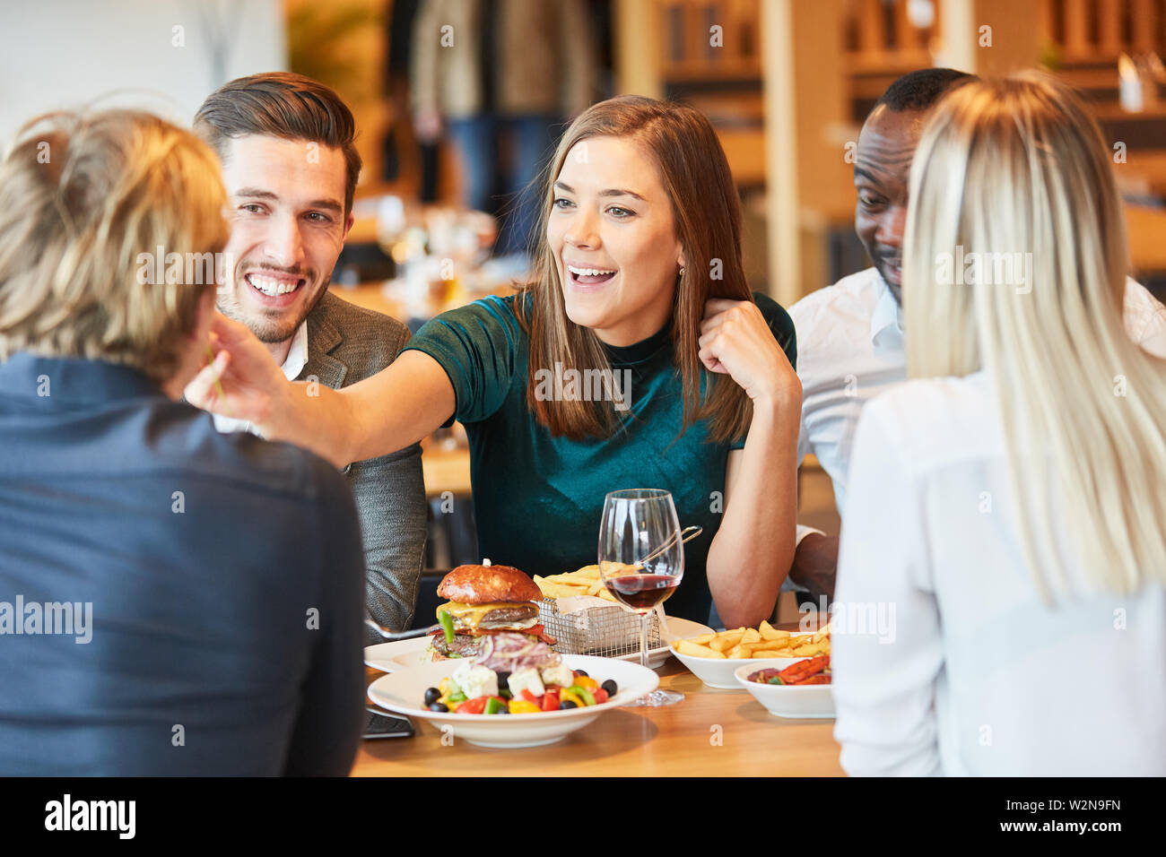 Jeune femme au restaurant avec des amis en train de déjeuner s'amuse Banque D'Images