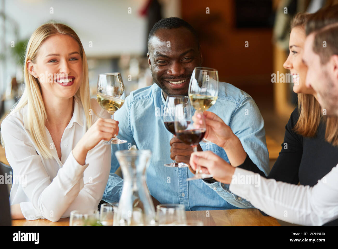 Groupe multiculturel d'amis a le plaisir de boire du vin au restaurant Banque D'Images