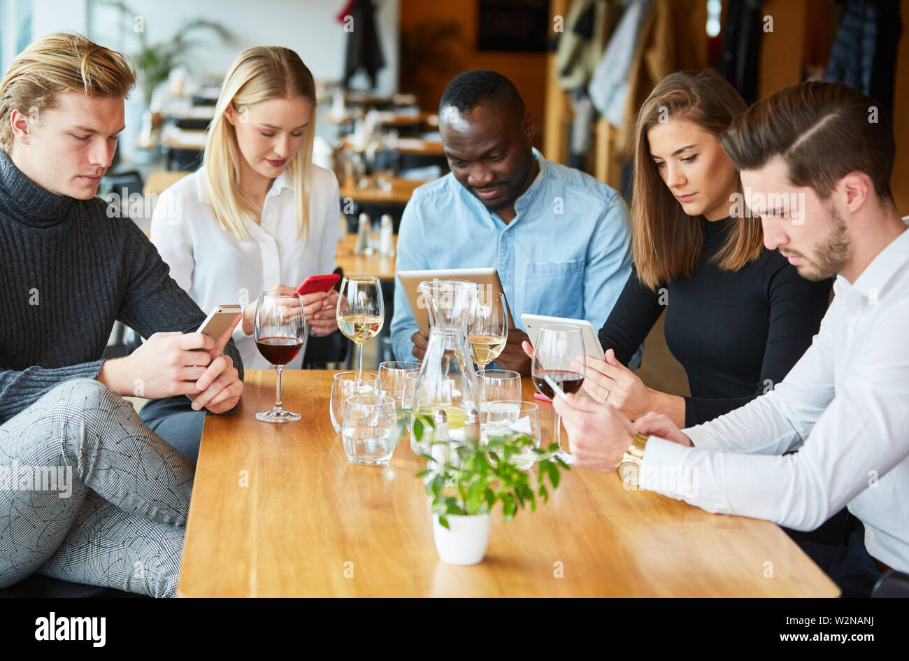 Les jeunes surf impoli avec portable et smartphone à la table dans le restaurant Banque D'Images