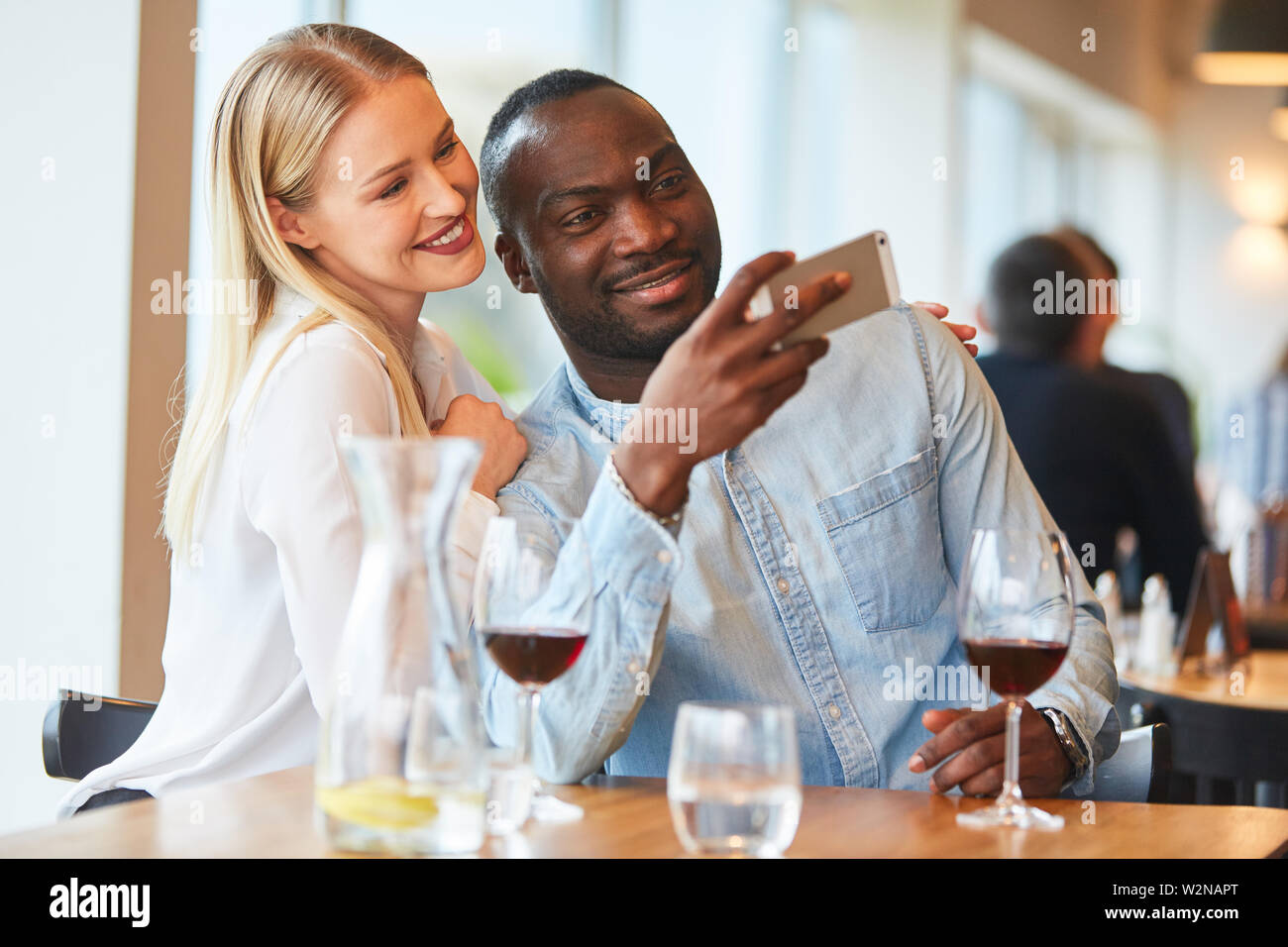 Amorous couple multiculturel prend une rendezvousing selfies tandis que dans le restaurant Banque D'Images